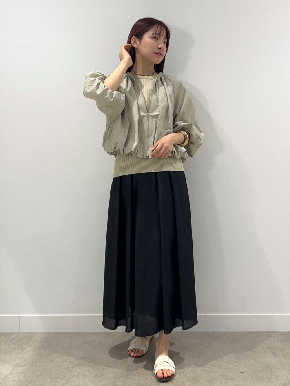 ベージュ系のブルゾン、ベージュ系のニット/セーター、ブラック系のスカートを着用したレディースの春コーディネートの5枚目の写真