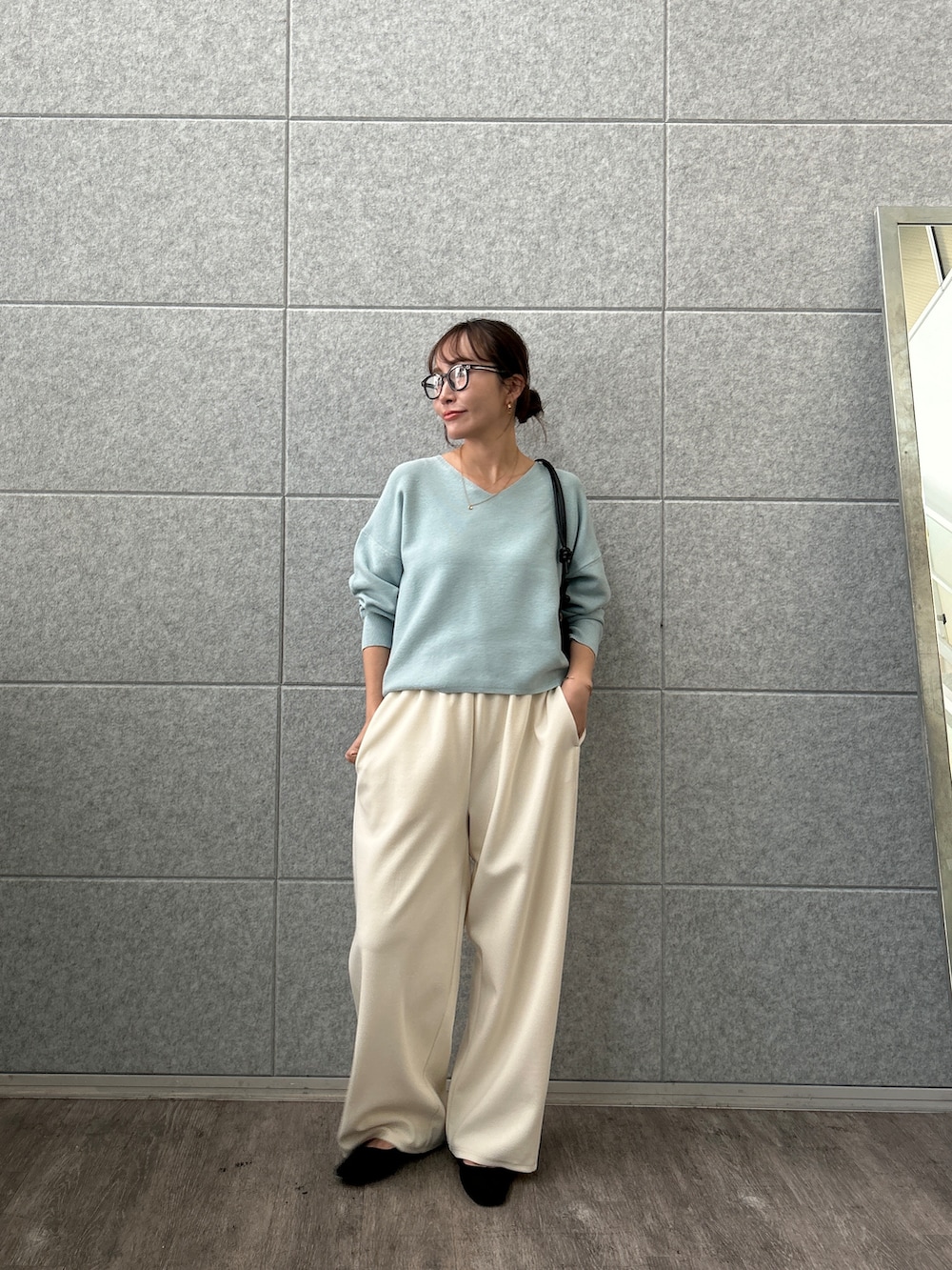 ブルー系のニット/セーター、ホワイト系のその他パンツを着用したレディースの秋コーディネートの6枚目の写真