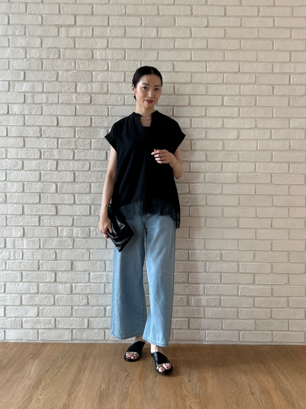 ブラック系のシャツ/ブラウス、ブルー系のデニムパンツを着用したレディースの春コーディネートの3枚目の写真