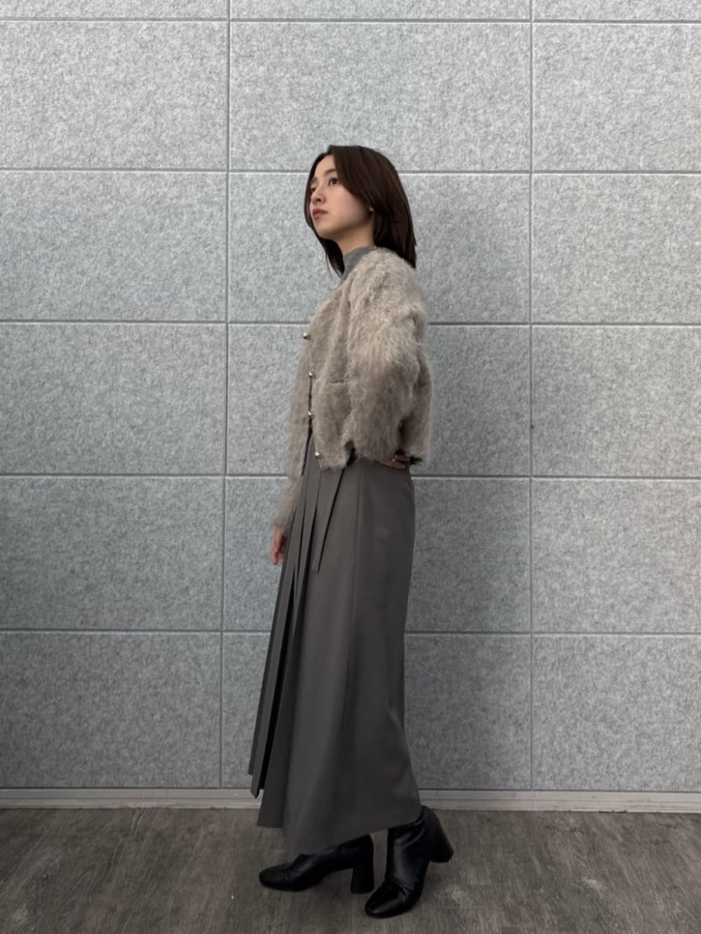 ブラウン系のニット/セーター、ベージュ系のカーディガン/ボレロ、グレー系のスカートを着用したレディースの秋コーディネートの2枚目の写真