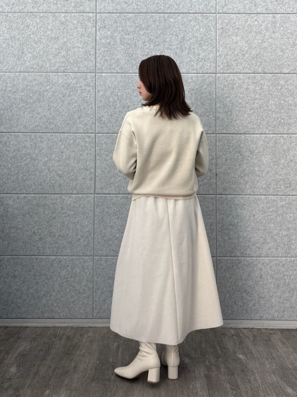 ホワイト系のスカート、ホワイト系のニット/セーター、ベージュ系のTシャツ/カットソーを着用したレディースの秋コーディネートの2枚目の写真