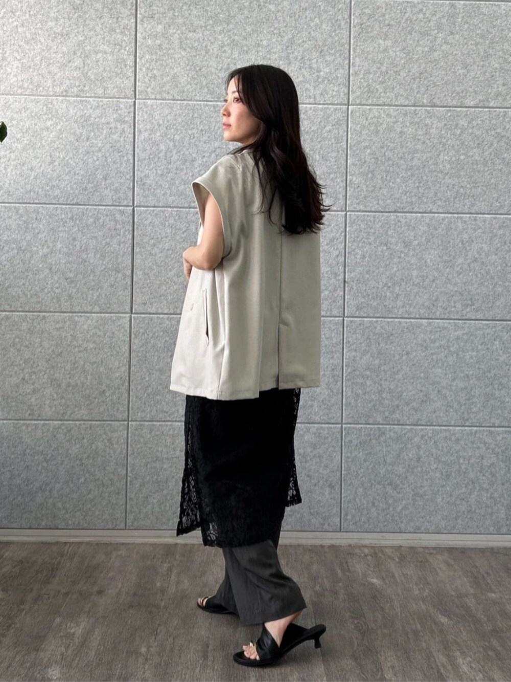 グリーン系のテーラードジャケット、ブラック系のワンピース、グレー系のその他パンツを着用したレディースの夏コーディネートの3枚目の写真