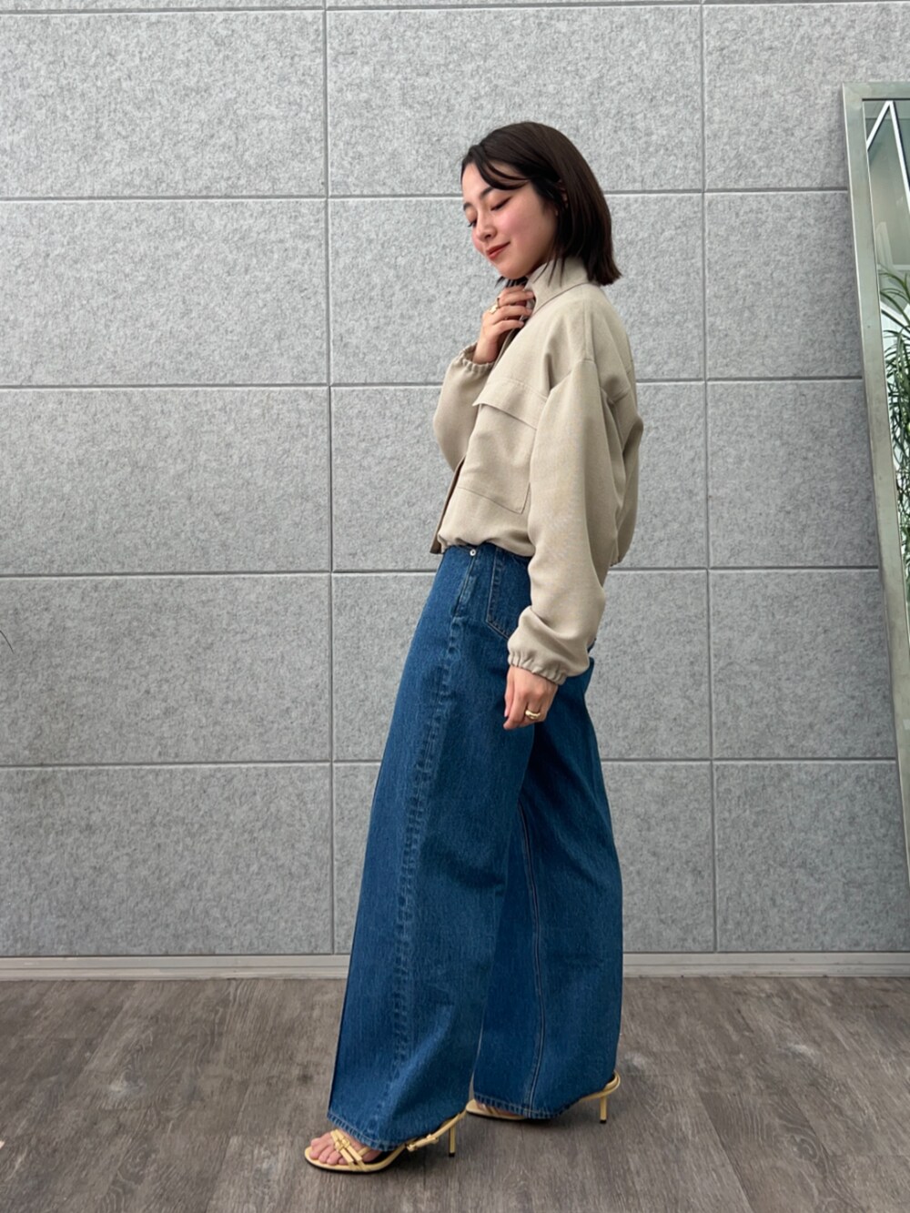 ブルー系のデニムパンツ、グリーン系のブルゾンを着用したレディースの春コーディネートの4枚目の写真