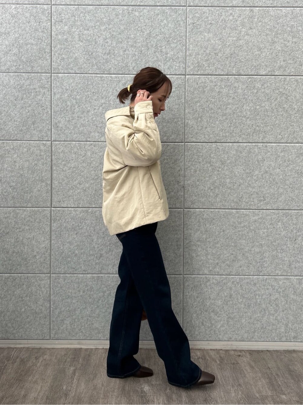 ベージュ系のブルゾン、ホワイト系のニット/セーター、ブルー系のデニムパンツを着用したレディースの冬コーディネートの6枚目の写真
