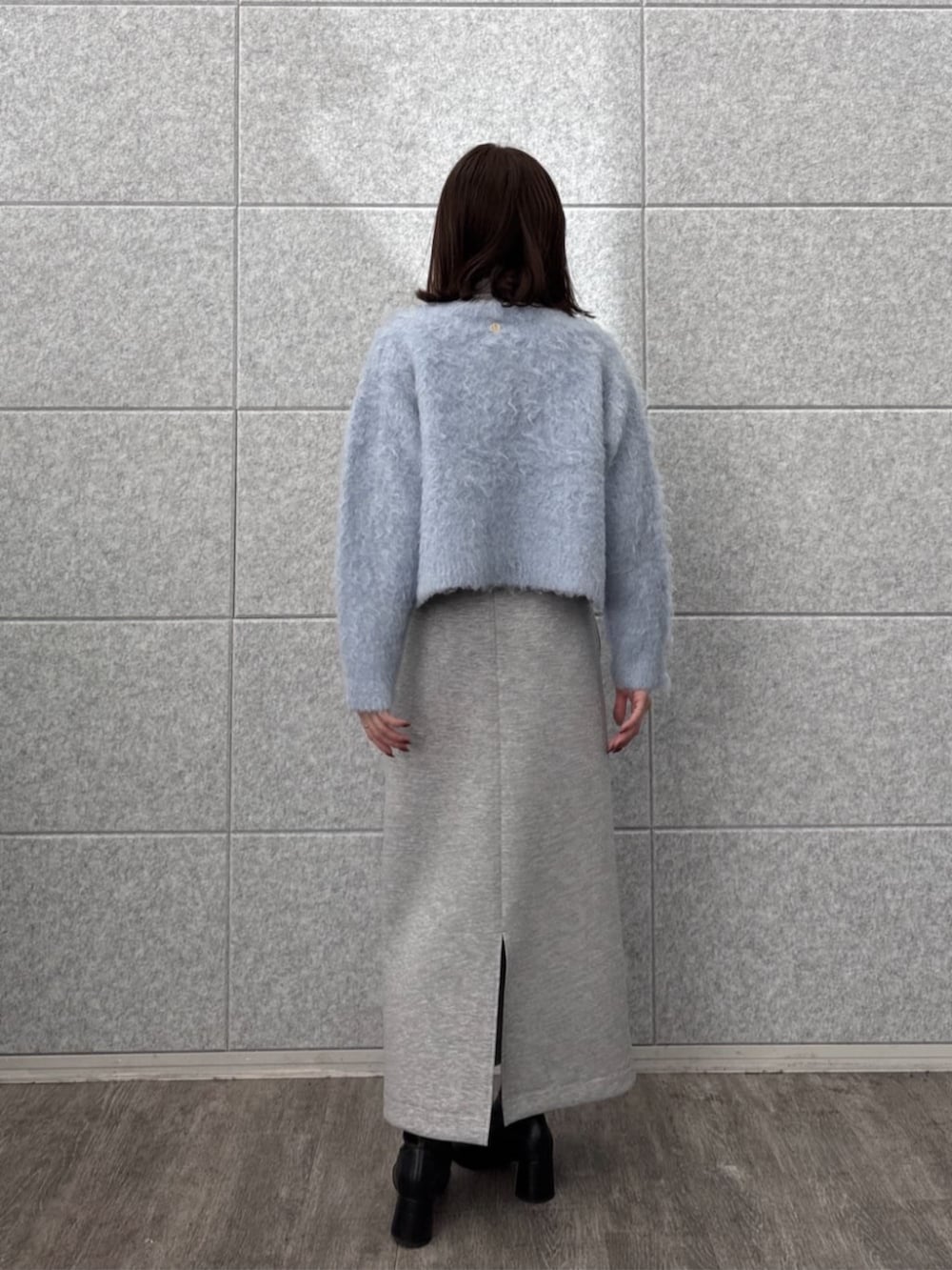 グレー系のスカート、グレー系のニット/セーター、ブルー系のカーディガン/ボレロを着用したレディースの秋コーディネートの4枚目の写真