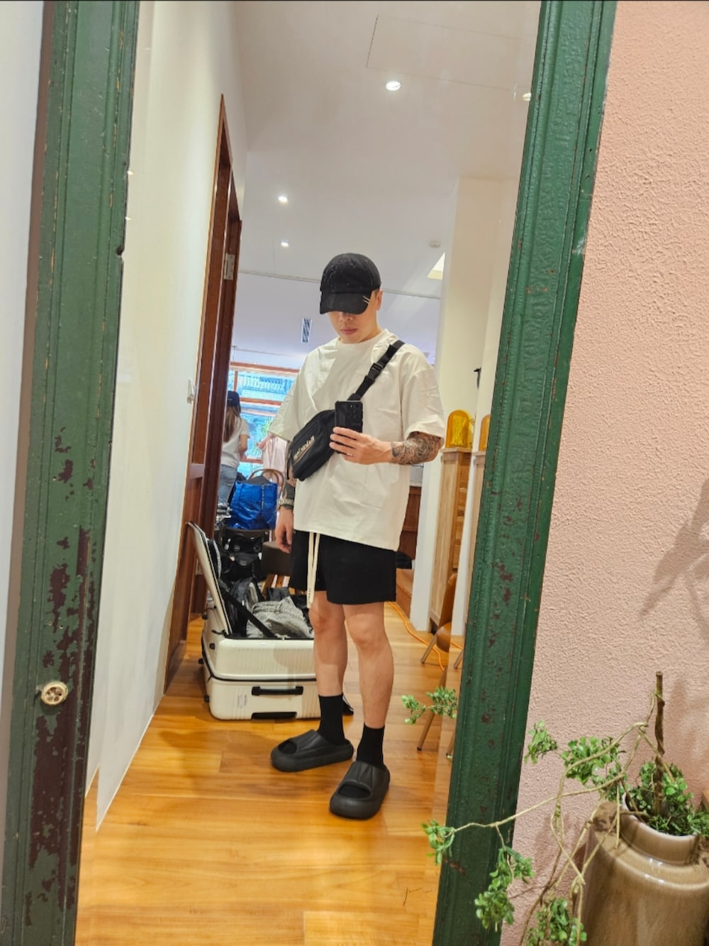 ブラック系のボディバッグ/ウエストポーチを着用したメンズの夏コーディネートの2枚目の写真