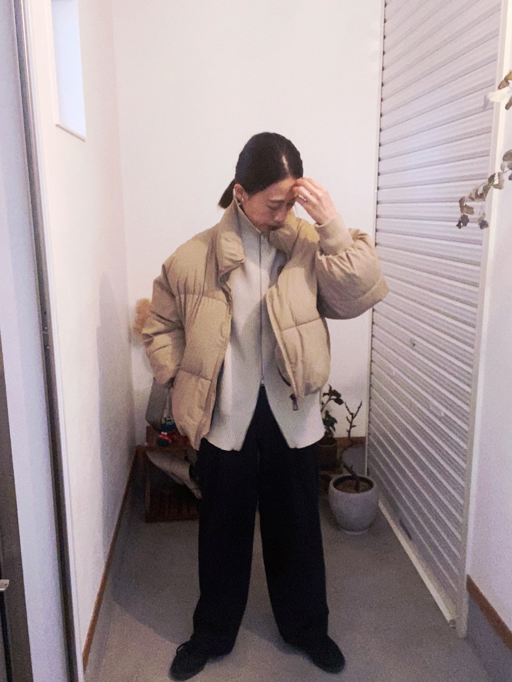 ベージュ系のダウンジャケット/コート、ブラック系のパンツ、ブラック系のスニーカーを着用したレディースの冬コーディネートの2枚目の写真