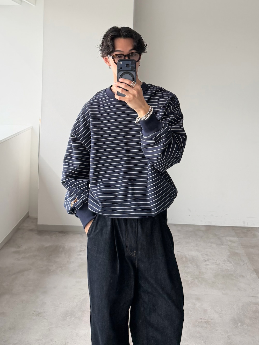 ブルー系のスウェット、ブルー系のデニムパンツ、ブラウン系のローファーを着用したメンズの秋コーディネートの2枚目の写真