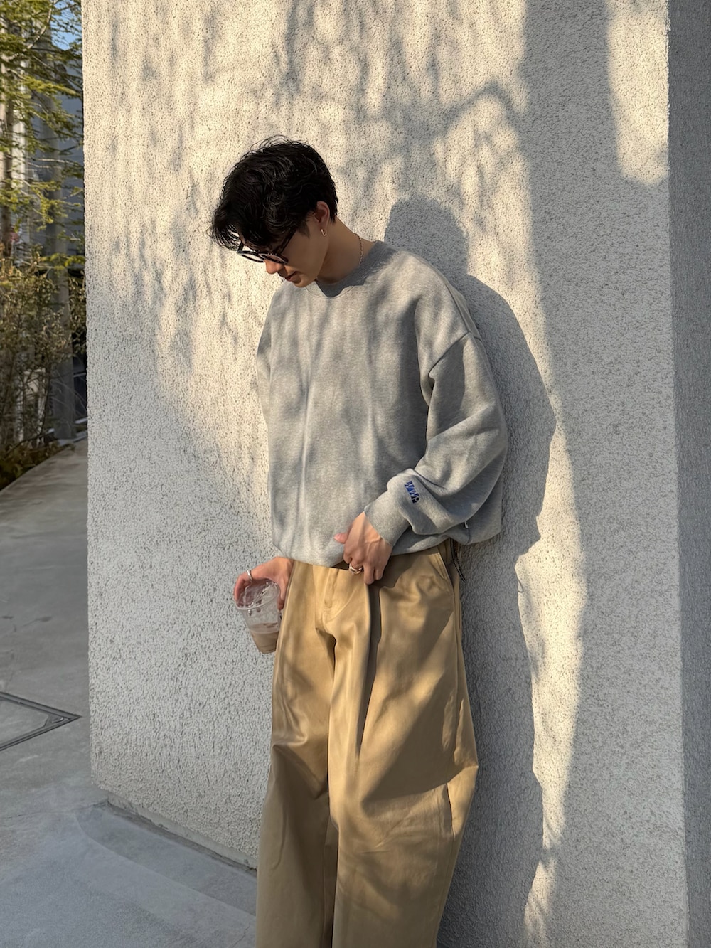 グレー系のスウェット、ベージュ系のその他パンツ、ブラック系のドレスシューズを着用したメンズの春コーディネートの2枚目の写真
