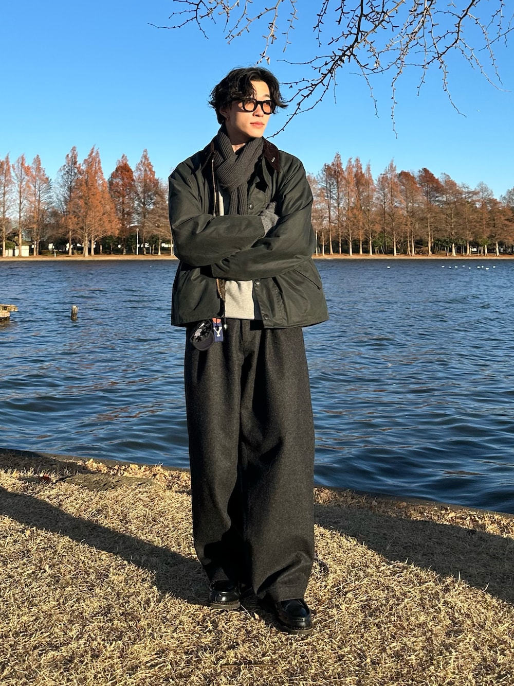 グレー系のスウェット、グリーン系のブルゾン、グレー系のスラックスを着用したメンズの冬コーディネートの2枚目の写真