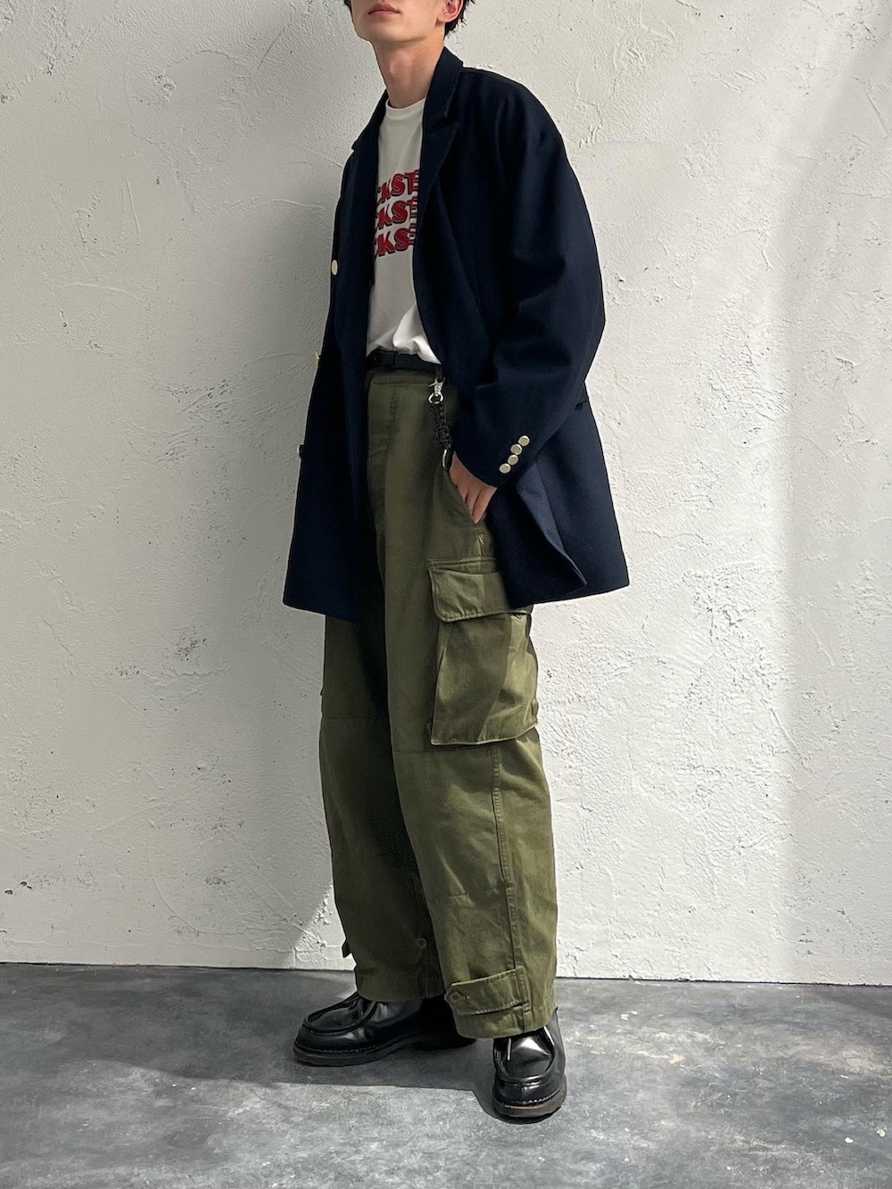 ホワイト系のTシャツ/カットソー、ブルー系のテーラードジャケット、グリーン系のカーゴパンツを着用したメンズの秋コーディネートの3枚目の写真