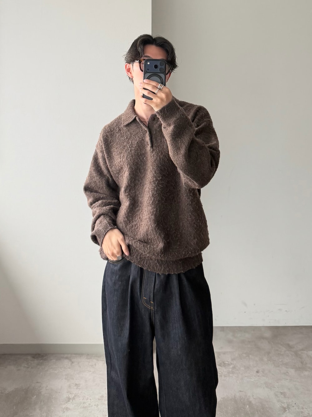 ブラウン系のニット/セーター、ブルー系のデニムパンツ、ブラック系のドレスシューズを着用したメンズの冬コーディネートの2枚目の写真