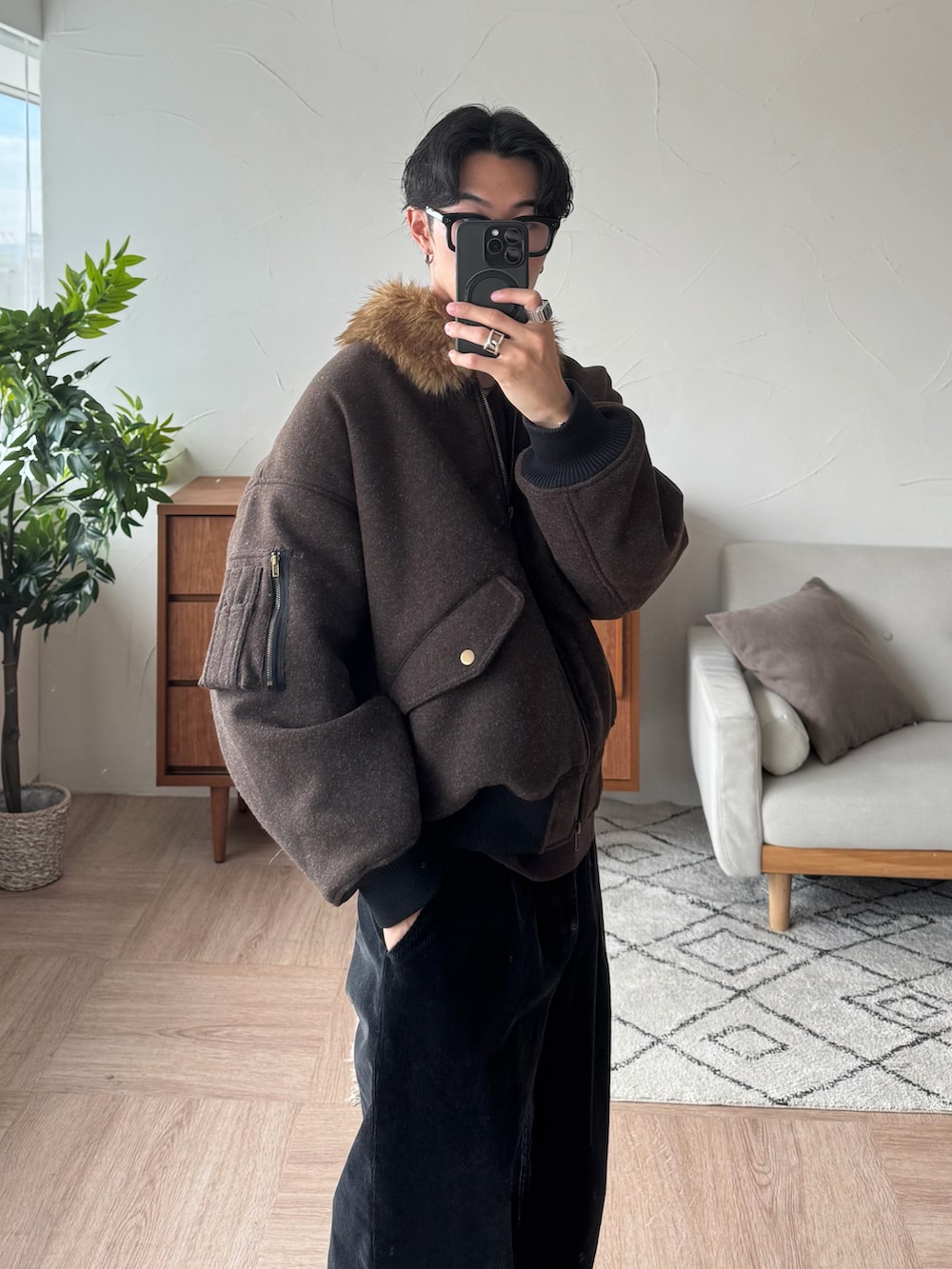 ブラウン系のブルゾン、ブラック系のスラックス、ブラック系のスニーカーを着用したメンズの秋コーディネートの2枚目の写真