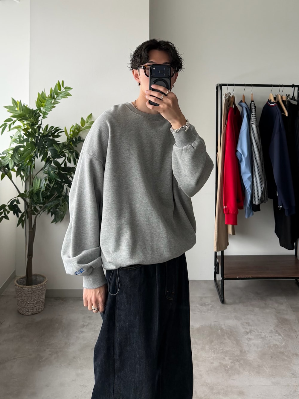 グレー系のスウェット、ブルー系のデニムパンツ、ブラック系のドレスシューズを着用したメンズの春コーディネートの2枚目の写真