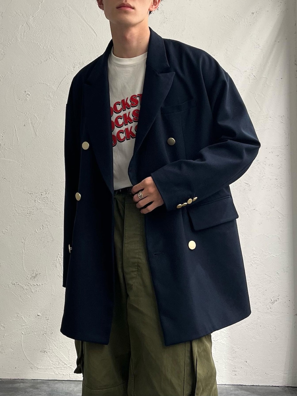 ホワイト系のTシャツ/カットソー、ブルー系のテーラードジャケット、グリーン系のカーゴパンツを着用したメンズの秋コーディネートの4枚目の写真