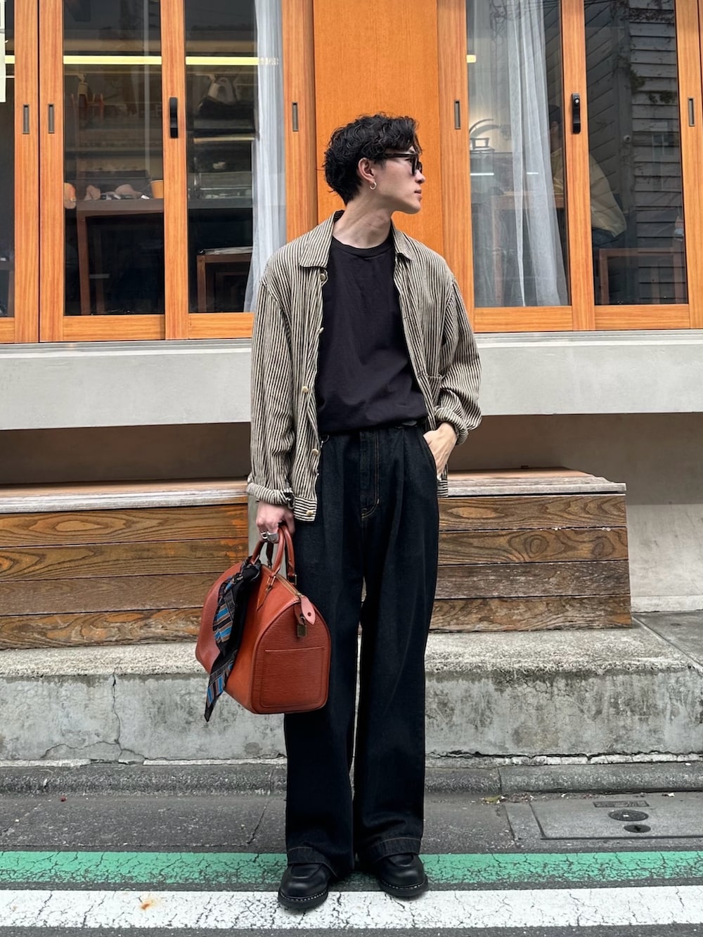 ブラック系のTシャツ/カットソー、ベージュ系のブルゾン、ブラック系のデニムパンツを着用したメンズの春コーディネートの2枚目の写真