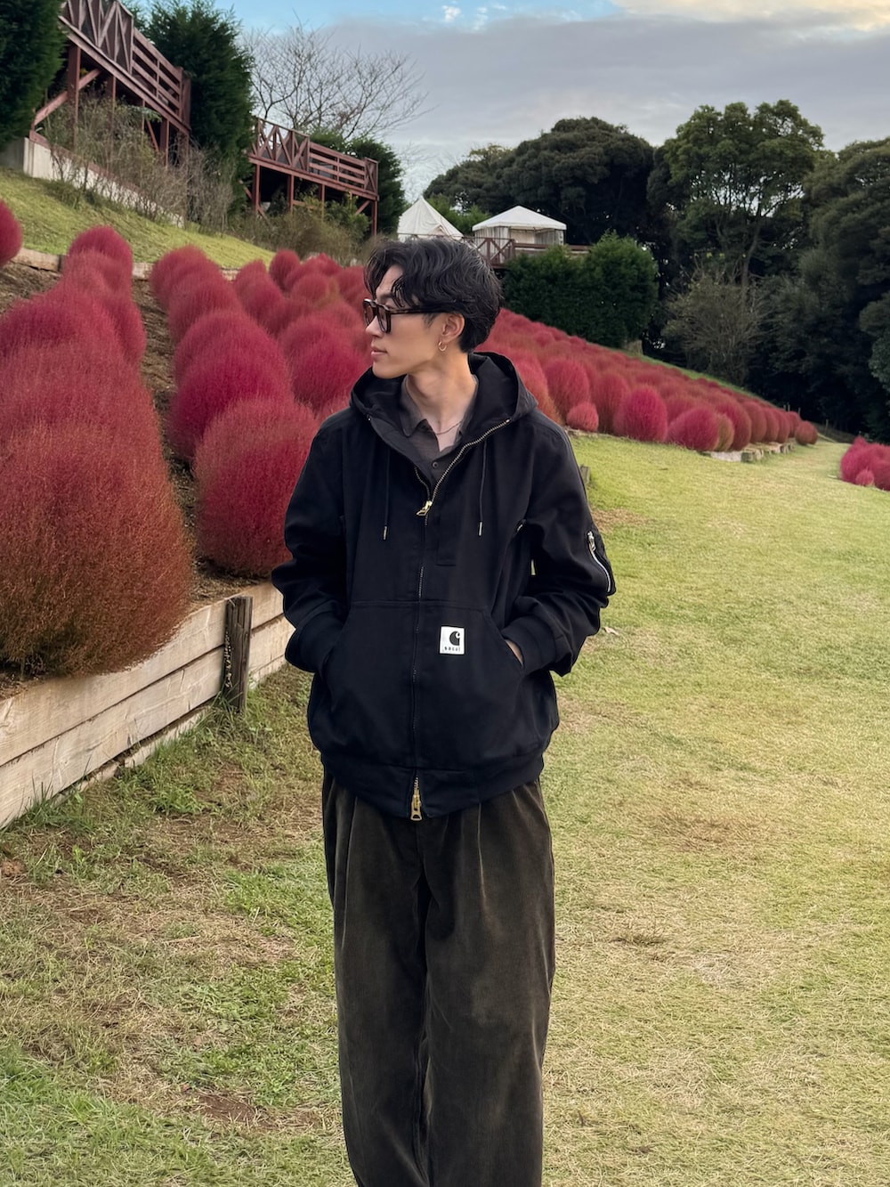 ブラック系のブルゾン、グリーン系のスラックス、ブラック系のスニーカーを着用したメンズの秋コーディネートの3枚目の写真