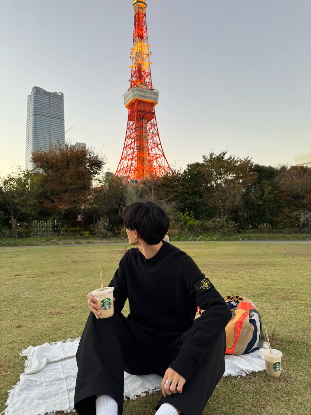 ブラック系のチノパンツ、ブラック系のスニーカー、ブラック系のニット/セーターを着用したメンズの秋コーディネートの2枚目の写真