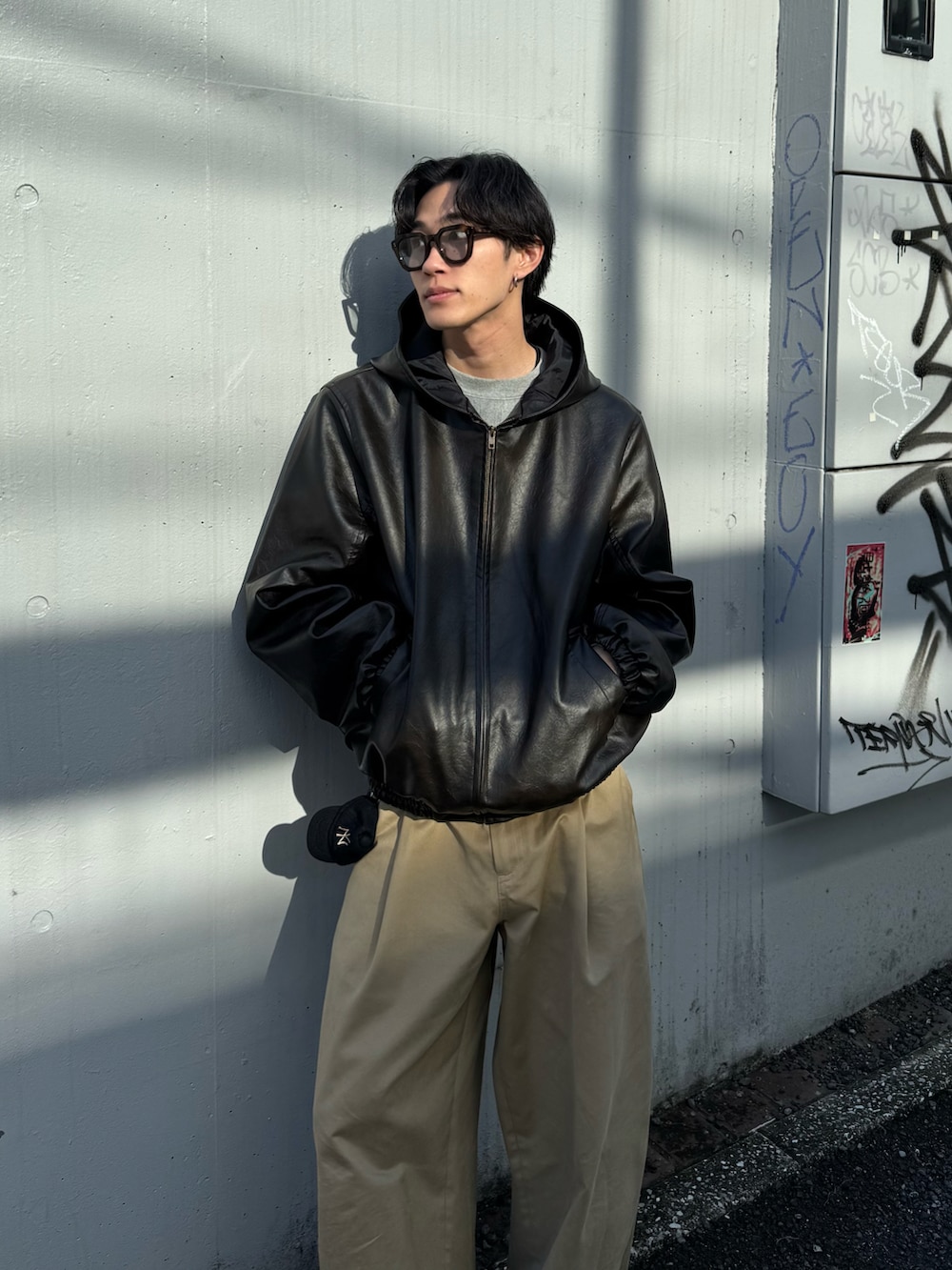 ブラック系のその他アウター、ベージュ系のその他パンツ、ブラック系のシューズを着用したメンズの冬コーディネートの3枚目の写真