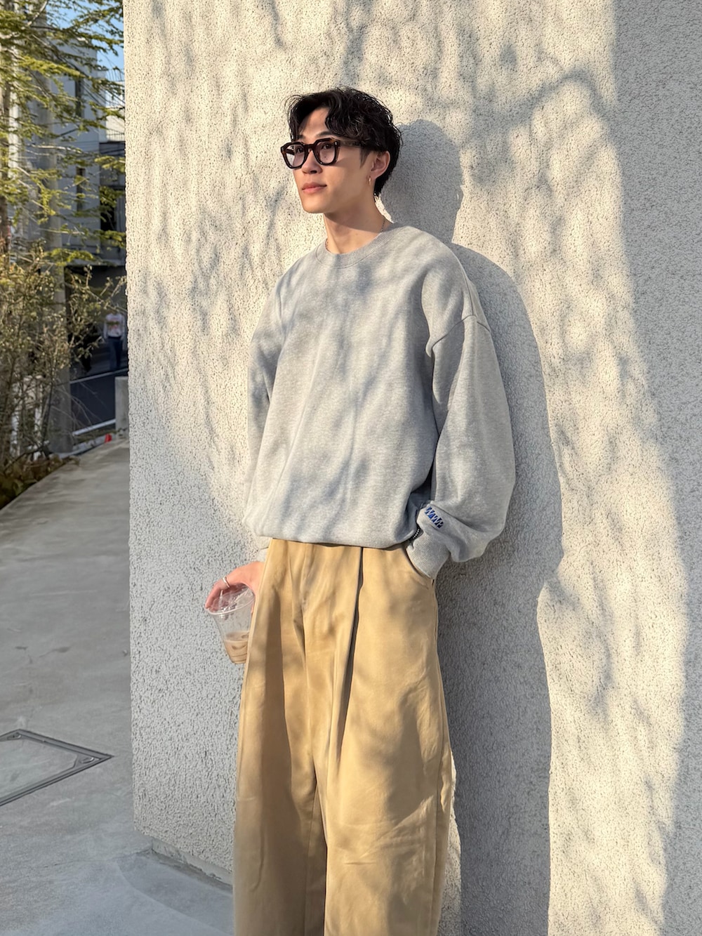 グレー系のスウェット、ベージュ系のその他パンツ、ブラック系のドレスシューズを着用したメンズの春コーディネートの3枚目の写真