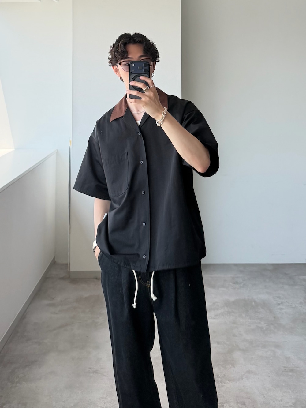 ブラック系のシャツ/ブラウス、ブラック系のデニムパンツ、ブラウン系のサングラスを着用したメンズの夏コーディネートの2枚目の写真