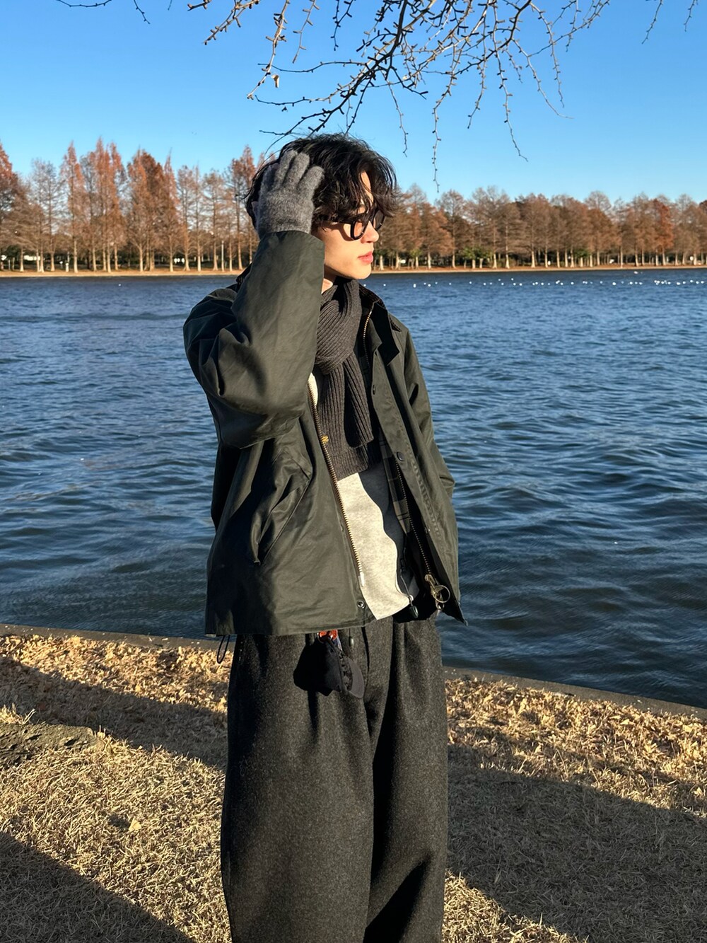 グレー系のスウェット、グリーン系のブルゾン、グレー系のスラックスを着用したメンズの冬コーディネートの3枚目の写真