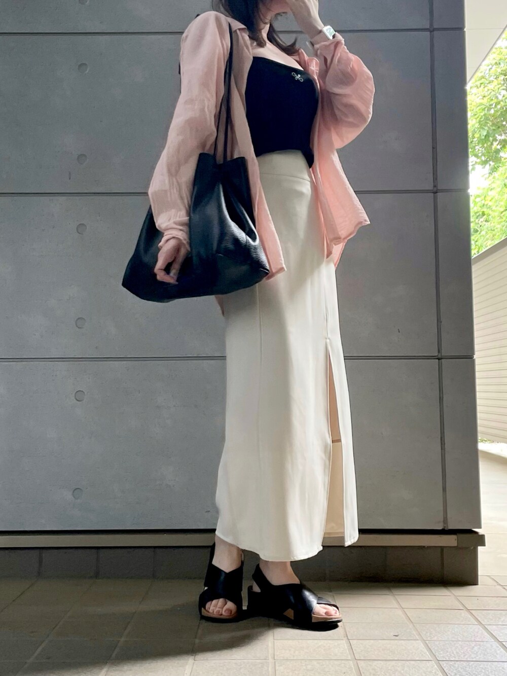 ブラック系のキャミソール、ブラック系のトートバッグを着用したレディースの秋コーディネートの2枚目の写真