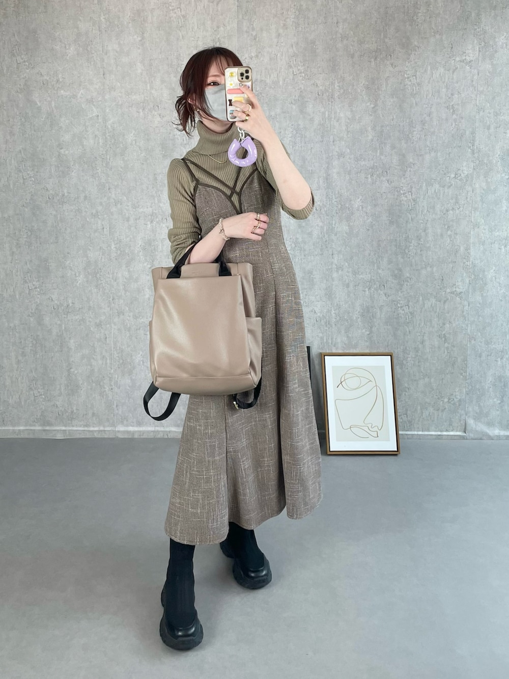 ベージュ系のトップス、ブラウン系のワンピース、ベージュ系のバックパック/リュックを着用したレディースの冬コーディネートの4枚目の写真