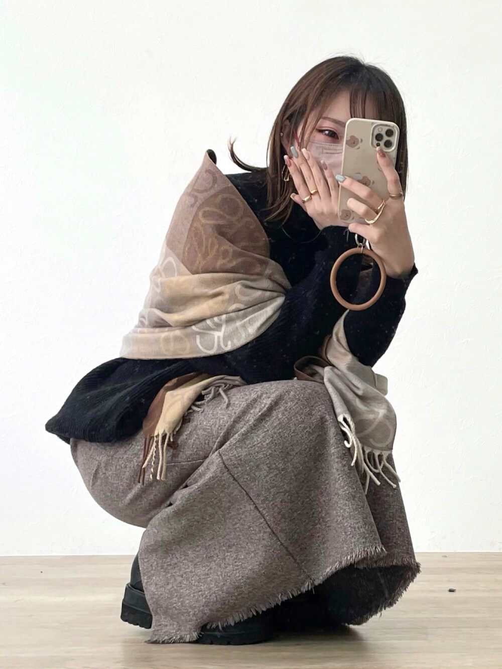 ブラウン系のスカート、ブラック系のブーツを着用したレディースの春コーディネートの2枚目の写真