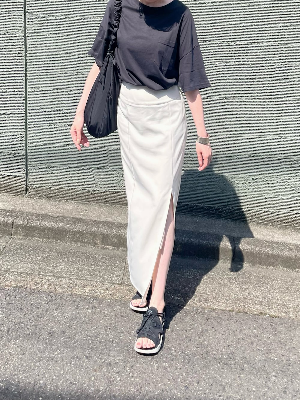 ブラック系のTシャツ/カットソー、ブラック系のショルダーバッグ、ブラック系のサンダルを着用したレディースの夏コーディネートの2枚目の写真