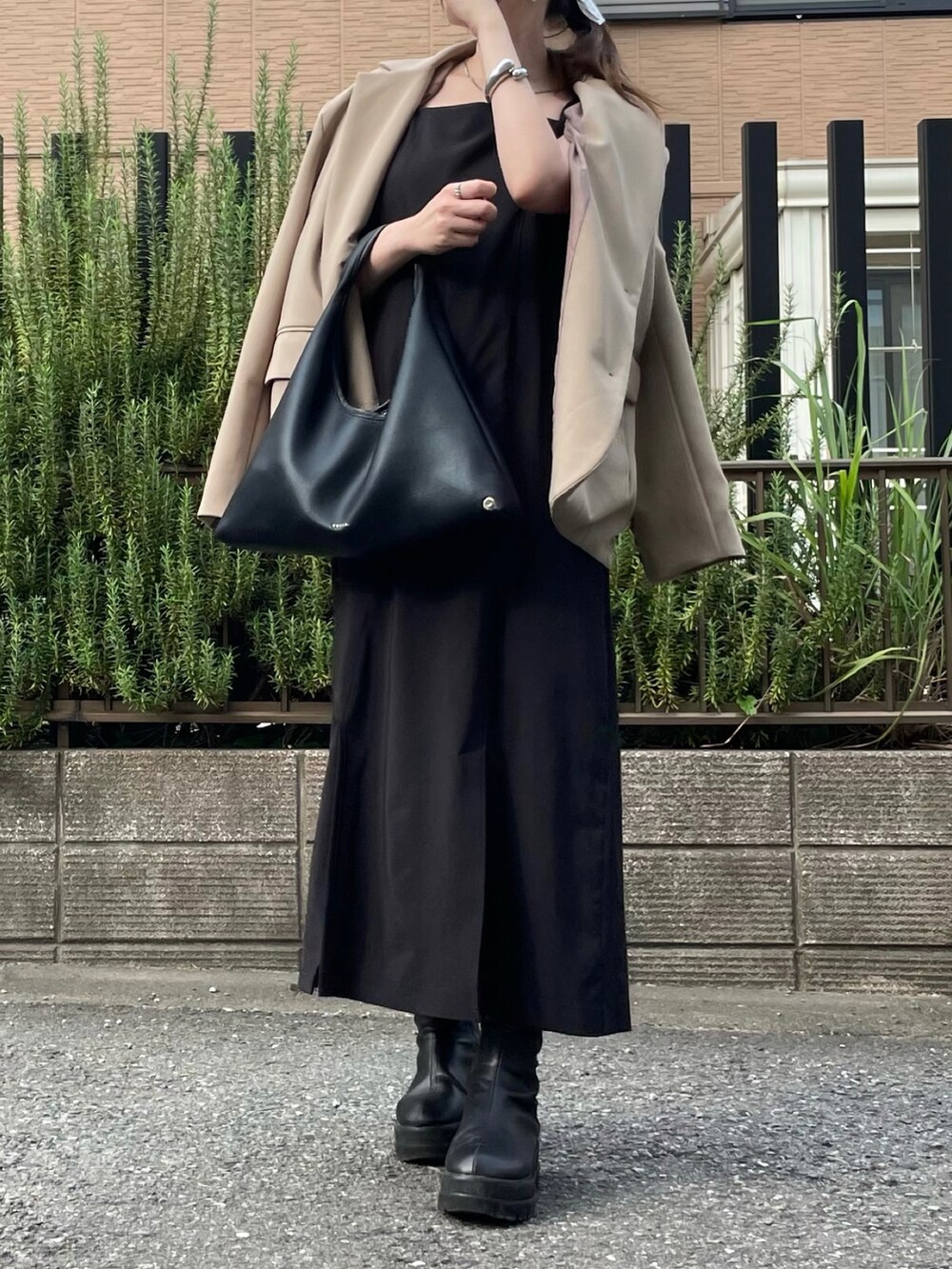 ブラック系のハンドバッグを着用したレディースの冬コーディネートの2枚目の写真