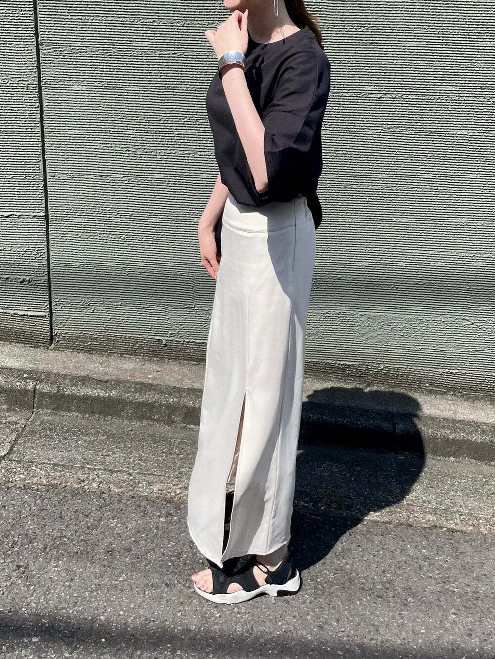 ブラック系のTシャツ/カットソー、ブラック系のショルダーバッグ、ブラック系のサンダルを着用したレディースの夏コーディネートの4枚目の写真