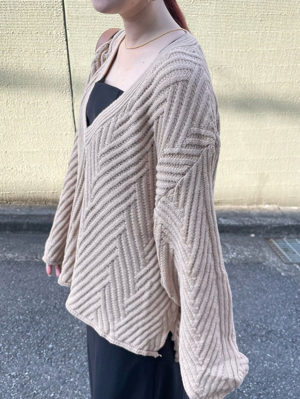 ベージュ系のニット/セーター、ブラウン系のハンドバッグを着用したレディースの冬コーディネートの2枚目の写真