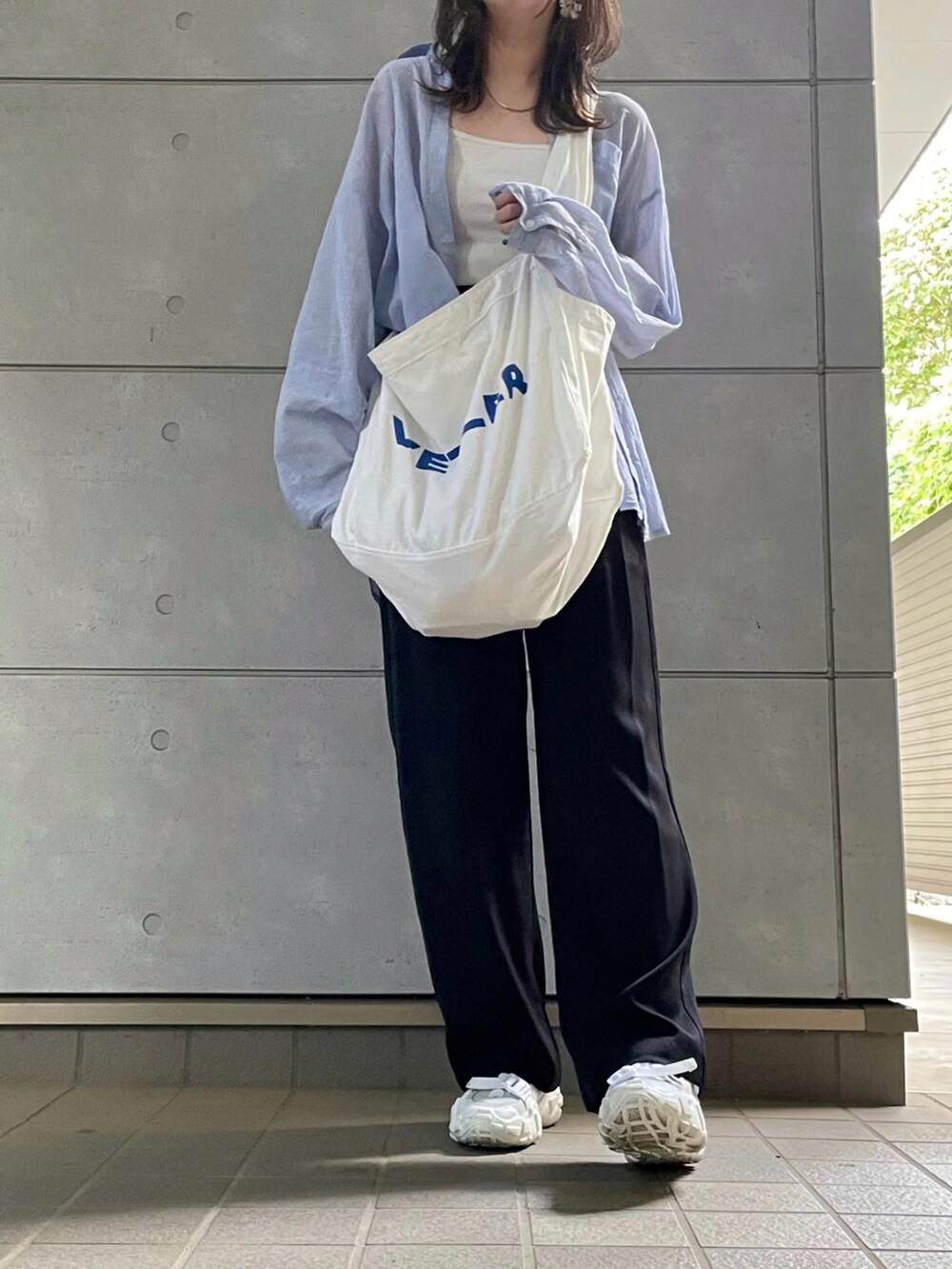 ブラック系のチノパンツを着用したレディースの秋コーディネートの2枚目の写真