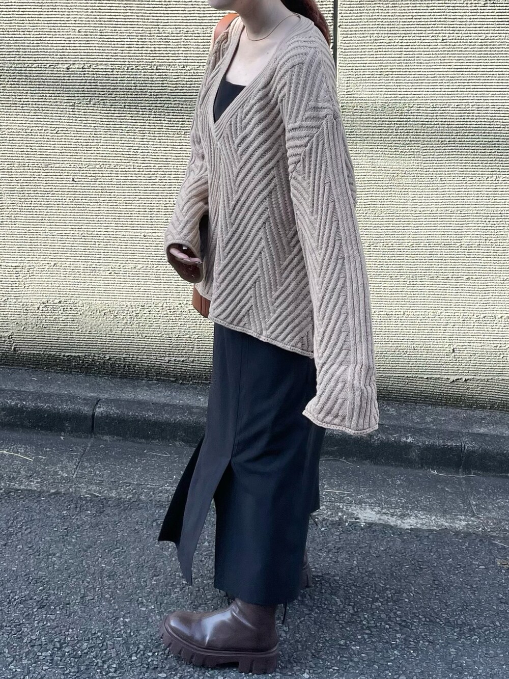 ベージュ系のニット/セーター、ブラウン系のハンドバッグを着用したレディースの冬コーディネートの4枚目の写真