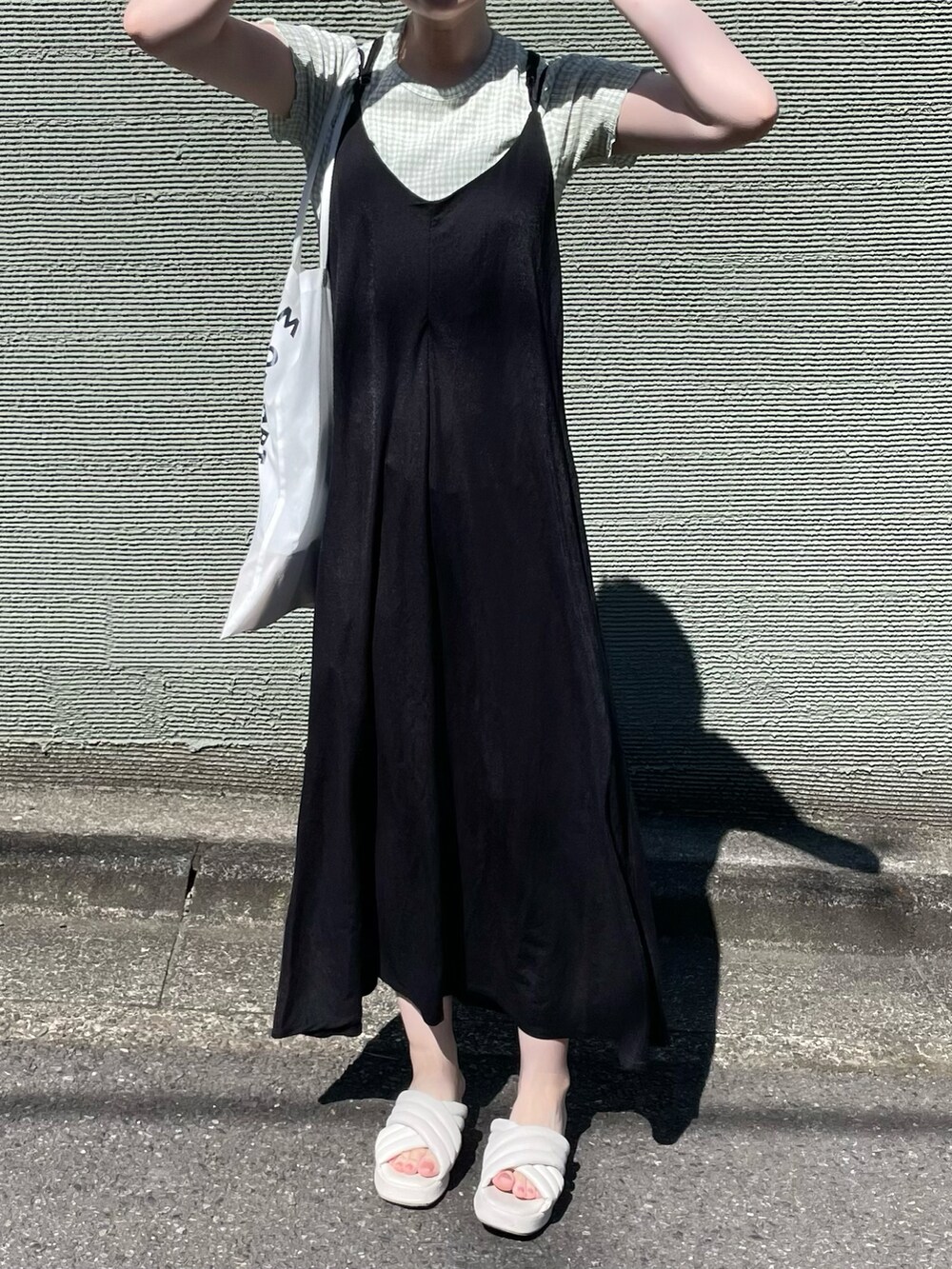 ブラック系のワンピース、ホワイト系のサンダルを着用したレディースの夏コーディネートの5枚目の写真