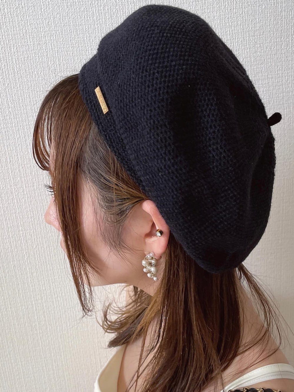 ホワイト系のワンピース、ブラック系のハンドバッグ、ベージュ系のカーディガン/ボレロを着用したレディースの秋コーディネートの3枚目の写真