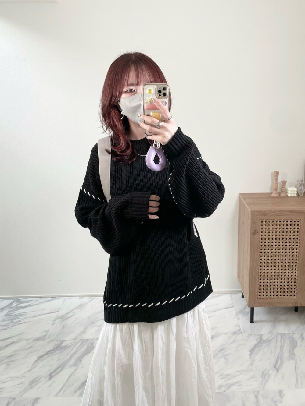 ブラック系のニット/セーター、ホワイト系のスカート、グレー系のバックパック/リュックを着用したレディースの秋コーディネートの3枚目の写真