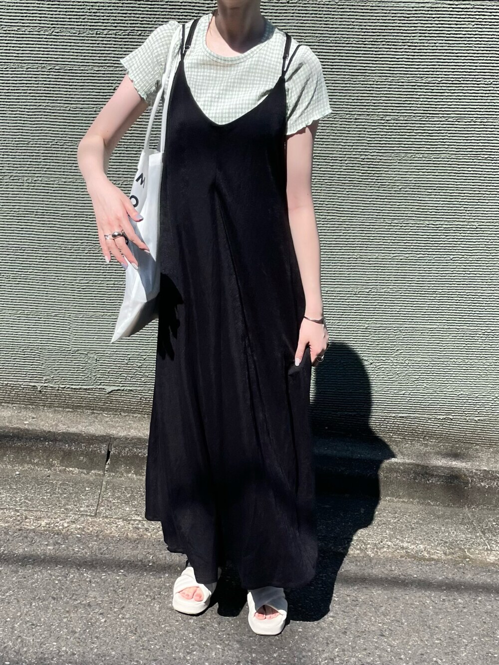 ブラック系のワンピース、ホワイト系のサンダルを着用したレディースの夏コーディネートの2枚目の写真