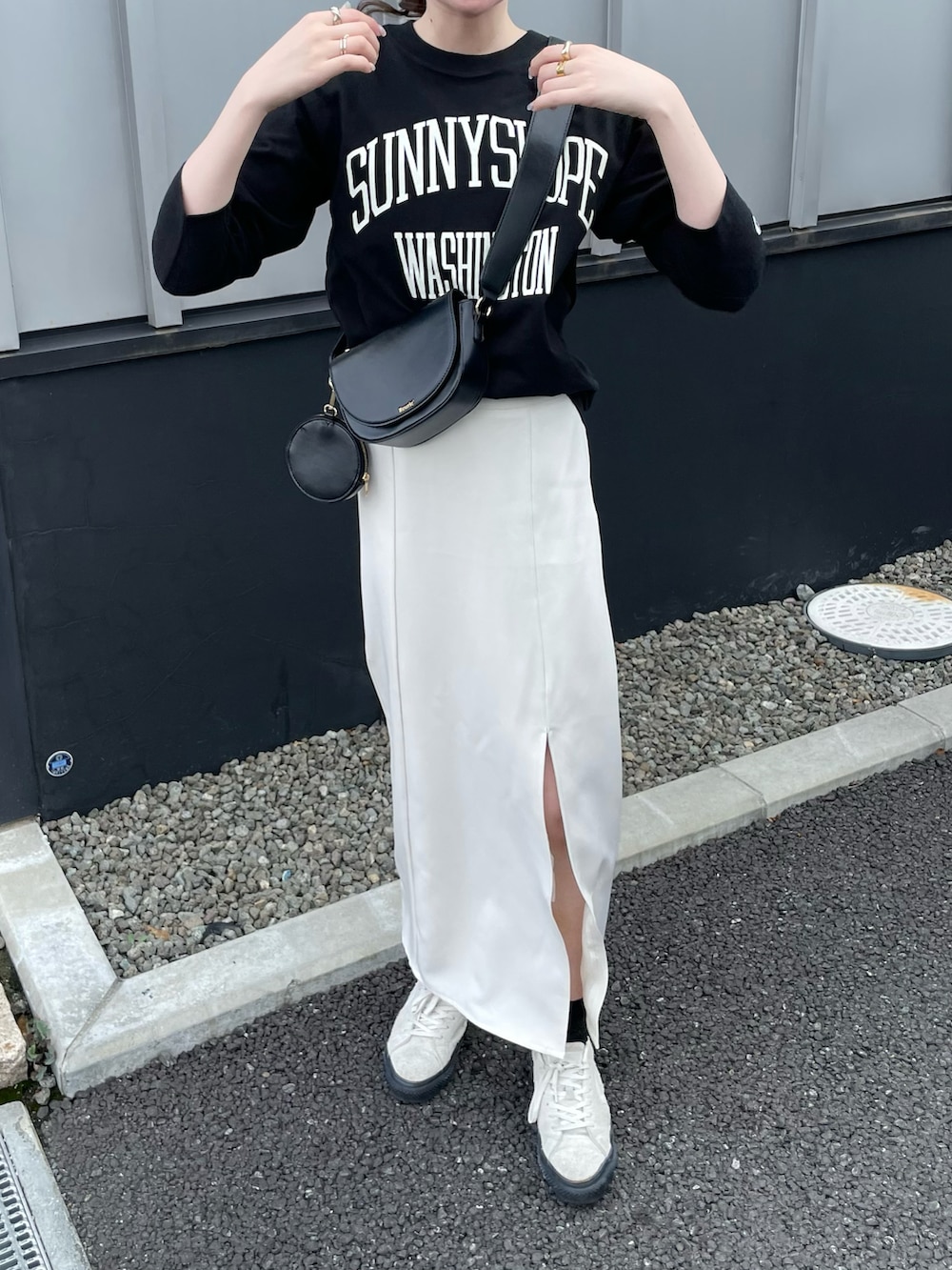 ブラック系のTシャツ/カットソー、ホワイト系のスニーカーを着用したレディースの秋コーディネートの2枚目の写真