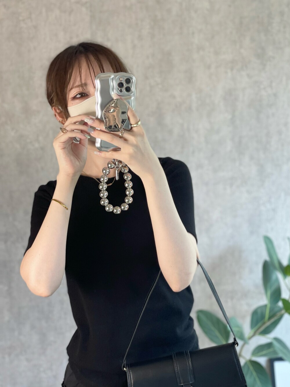 ブラック系のTシャツ/カットソー、ブラック系のスカート、ブラック系のローファーを着用したレディースの秋コーディネートの4枚目の写真