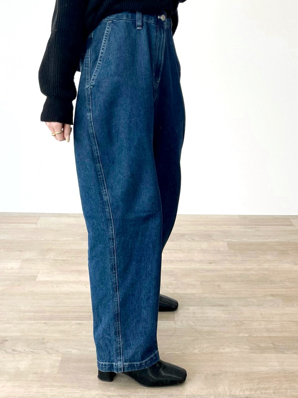 ブルー系のデニムパンツ、ブラック系のニット/セーターを着用したレディースの冬コーディネートの2枚目の写真