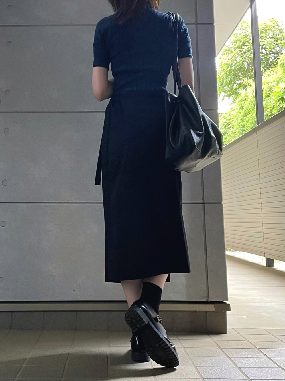 ブラック系のトートバッグ、ブラック系のシューズを着用したレディースの夏コーディネートの4枚目の写真