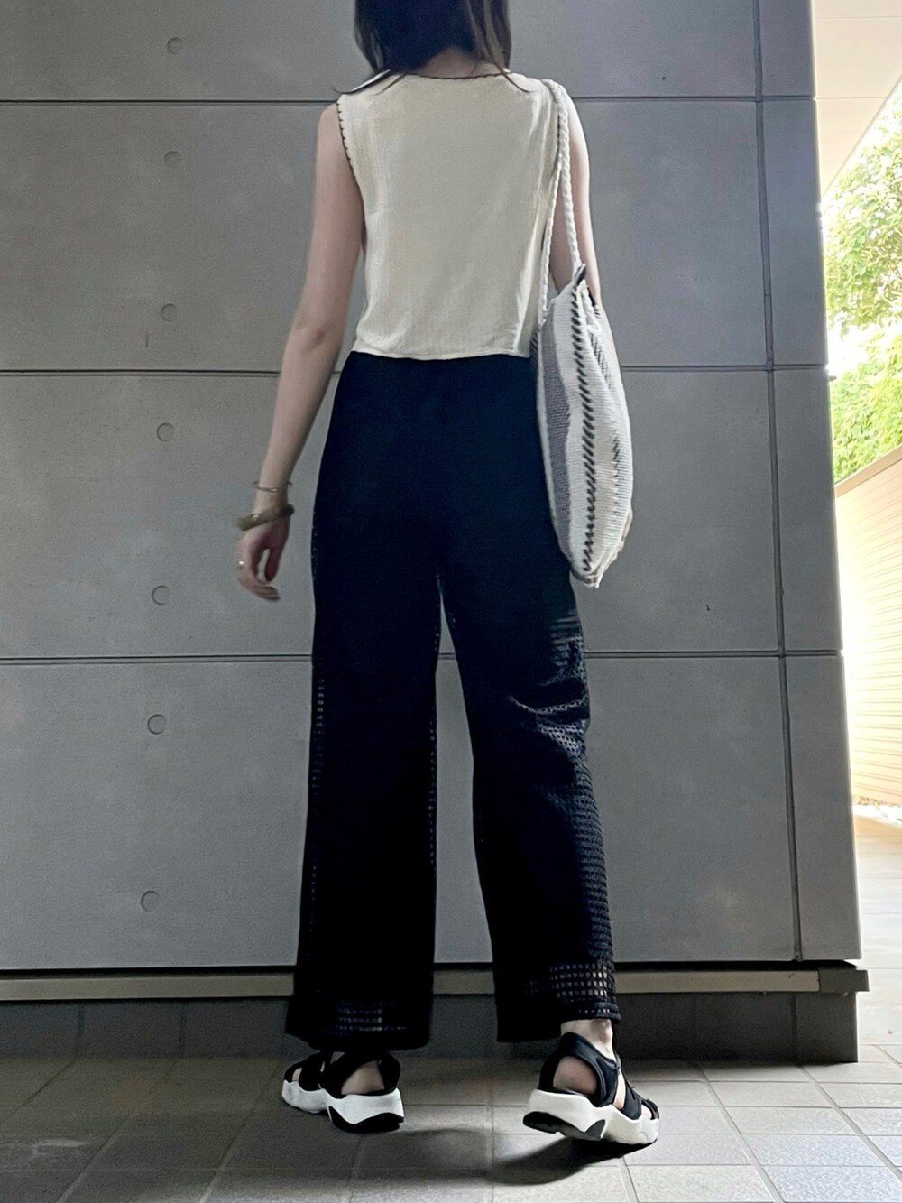 ブラック系のサンダル、ブラック系のその他パンツを着用したレディースの秋コーディネートの4枚目の写真