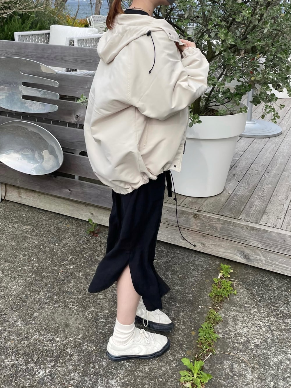 ホワイト系のマウンテンパーカー、ホワイト系のスニーカーを着用したレディースの春コーディネートの3枚目の写真