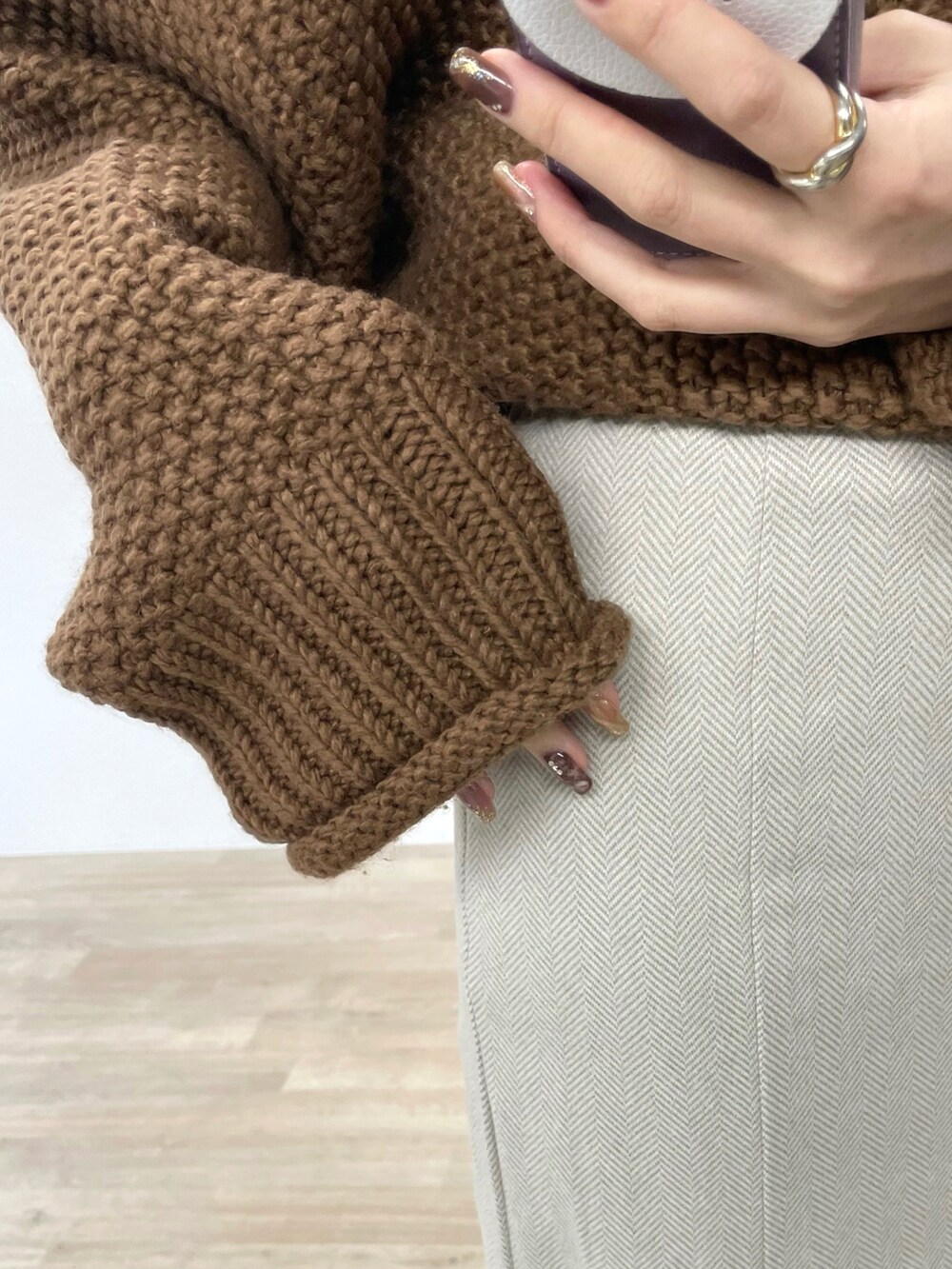 ホワイト系のスカート、イエロー系のニット/セーター、ブラック系のブーツを着用したレディースの冬コーディネートの4枚目の写真