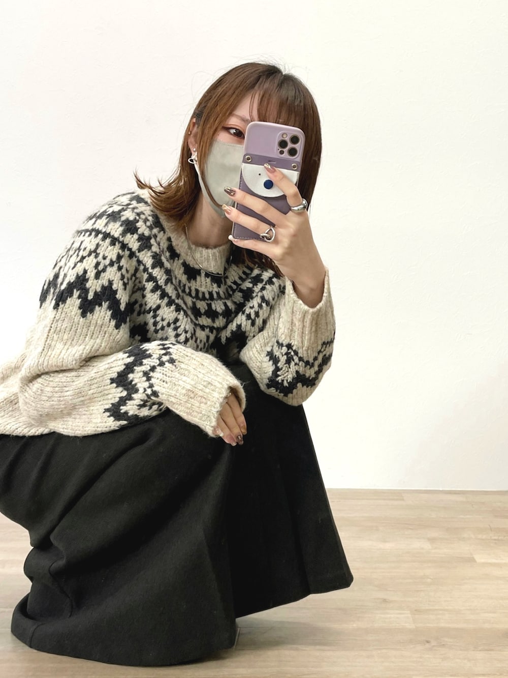 ホワイト系のニット/セーター、ブラック系のブーツを着用したレディースの冬コーディネートの2枚目の写真
