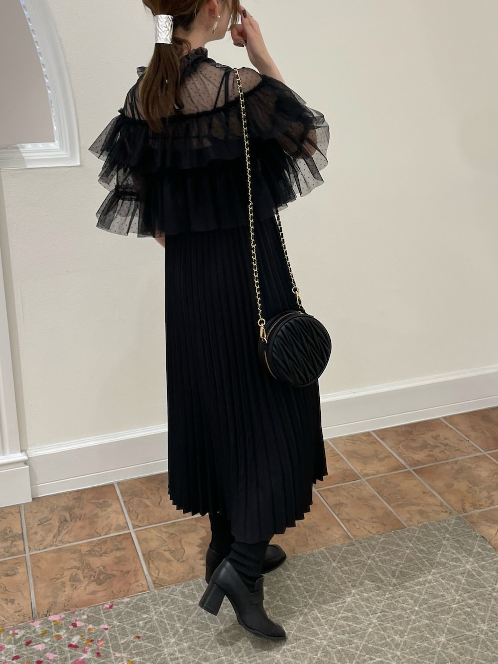 ブラック系のドレス、ブラック系のハンドバッグ、ブラック系のローファーを着用したレディースの秋コーディネートの3枚目の写真