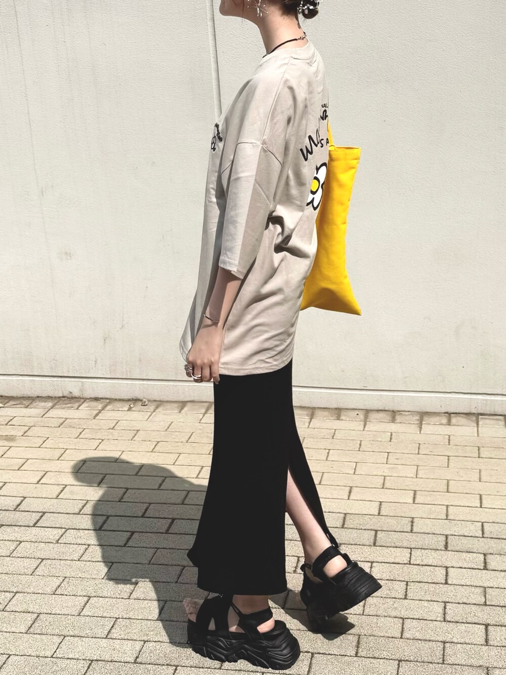 ベージュ系のTシャツ/カットソーを着用したレディースの夏コーディネートの2枚目の写真