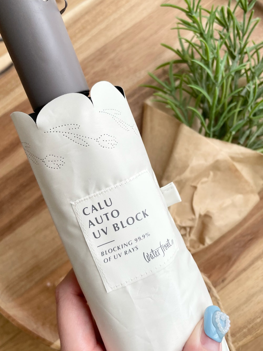 ホワイト系の折りたたみ傘を着用したレディースの夏コーディネートの4枚目の写真